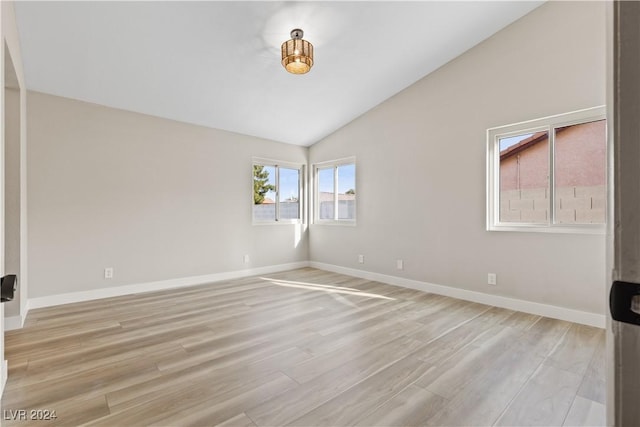 spare room featuring vaulted ceiling and light hardwood / wood-style flooring