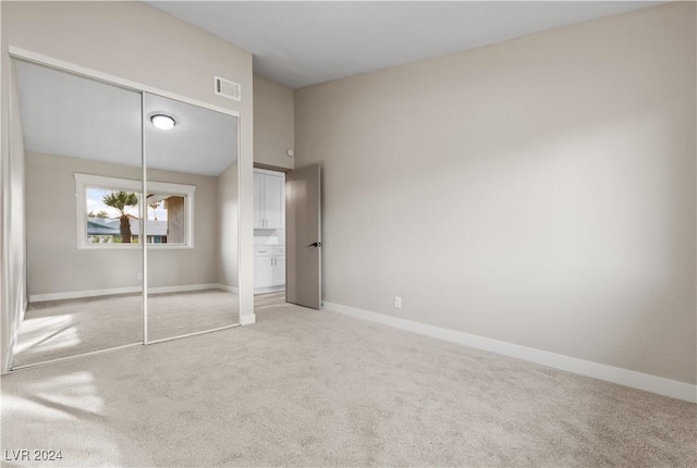 unfurnished bedroom featuring carpet flooring and a closet