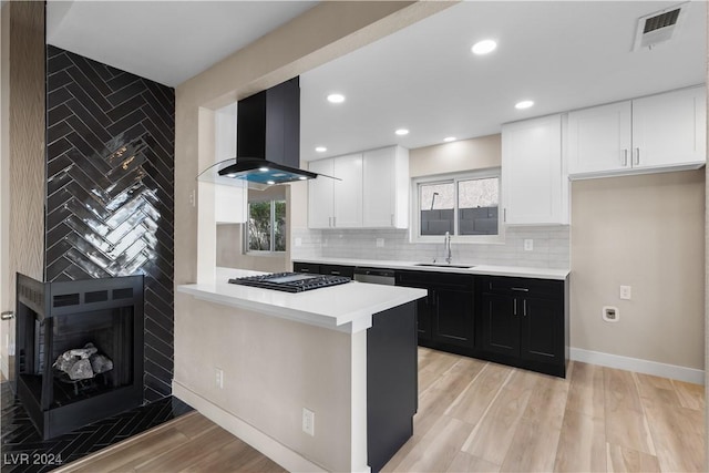 kitchen featuring plenty of natural light, white cabinetry, a fireplace, and extractor fan