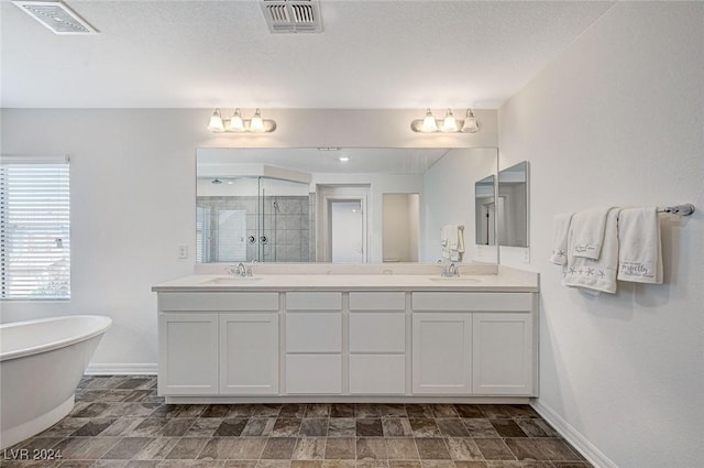 bathroom featuring vanity, a textured ceiling, and shower with separate bathtub