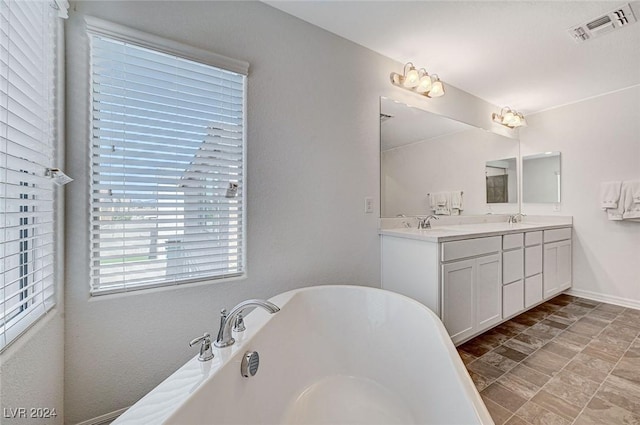 bathroom featuring a washtub and vanity