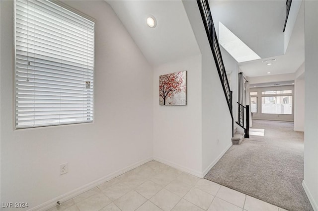 hall featuring light carpet and lofted ceiling