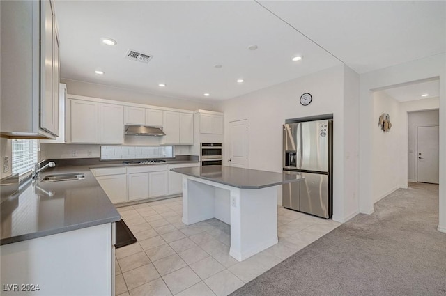 kitchen featuring sink, a kitchen island, light colored carpet, white cabinetry, and stainless steel appliances