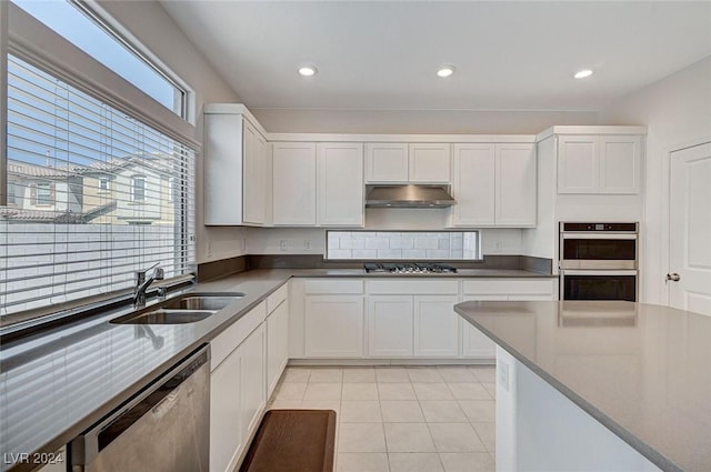 kitchen featuring light tile patterned flooring, white cabinetry, sink, and appliances with stainless steel finishes