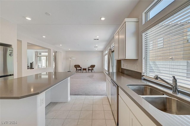 kitchen with light carpet, sink, white cabinets, and appliances with stainless steel finishes