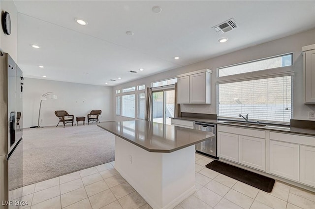 kitchen featuring dishwasher, light colored carpet, white cabinetry, and sink