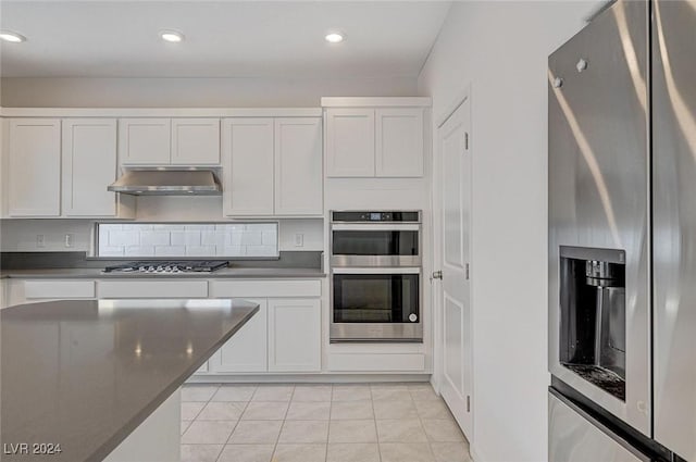 kitchen with white cabinets, light tile patterned flooring, and appliances with stainless steel finishes