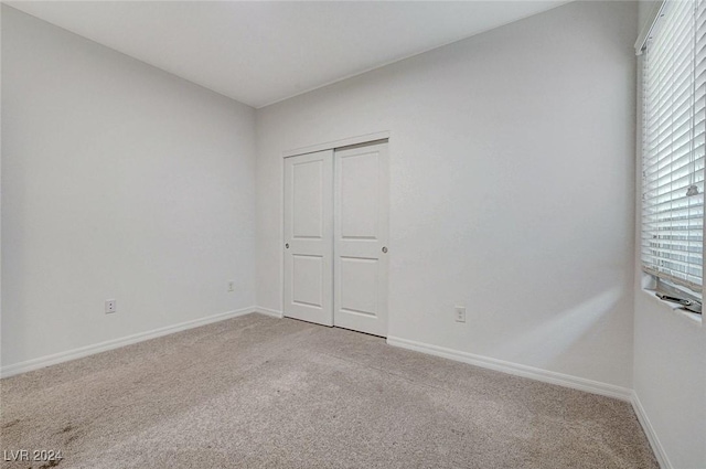 unfurnished bedroom featuring carpet and a closet