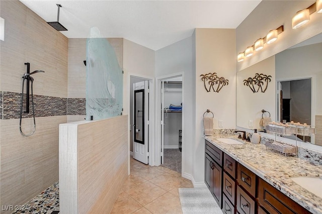 bathroom with tile patterned flooring, vanity, walk in shower, and tile walls