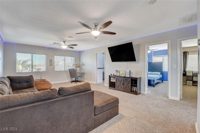 carpeted living room with ceiling fan