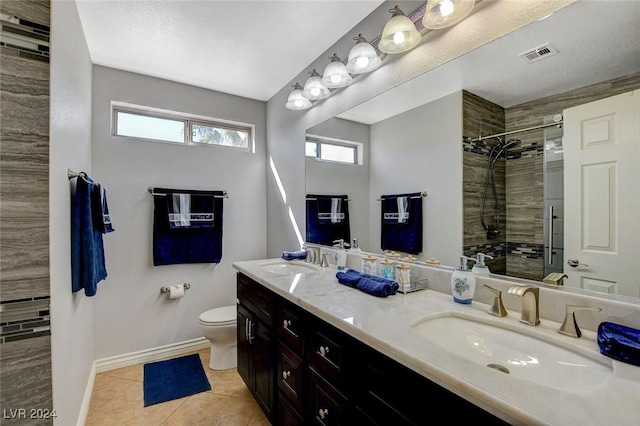 bathroom with vanity, tile patterned flooring, toilet, a textured ceiling, and an enclosed shower