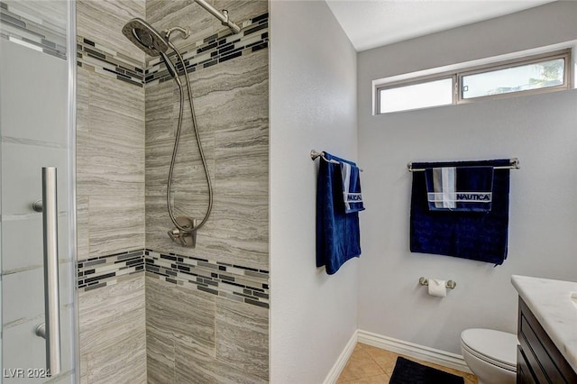 bathroom featuring tile patterned floors, vanity, toilet, and a tile shower