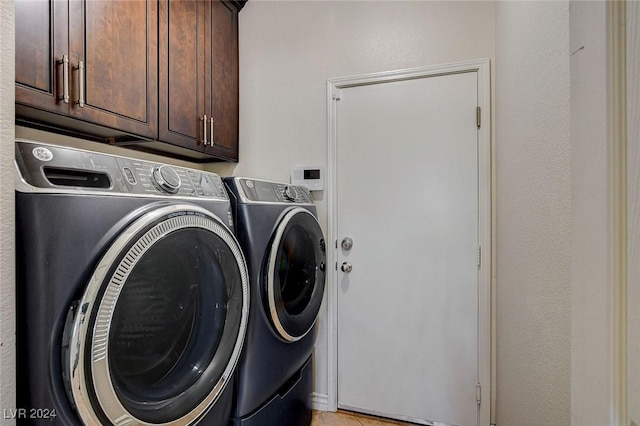 clothes washing area with cabinets and independent washer and dryer