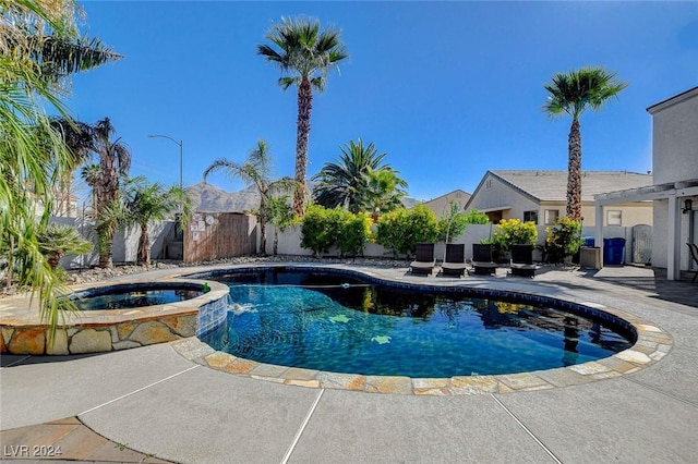 view of swimming pool featuring an in ground hot tub and a patio