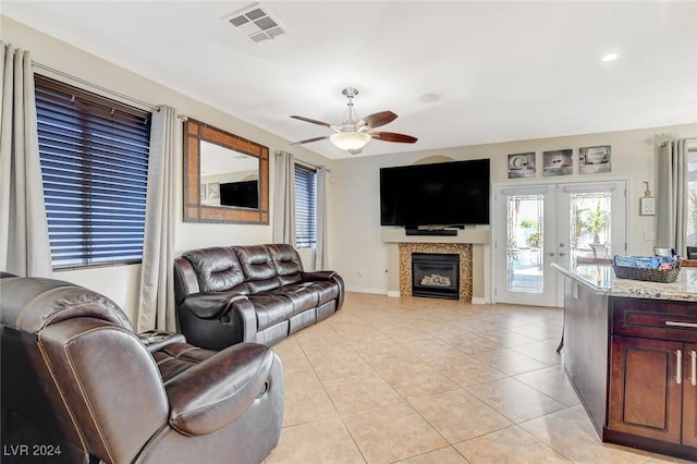 living room featuring ceiling fan, french doors, and light tile patterned floors