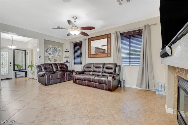 tiled living room with ceiling fan and a healthy amount of sunlight