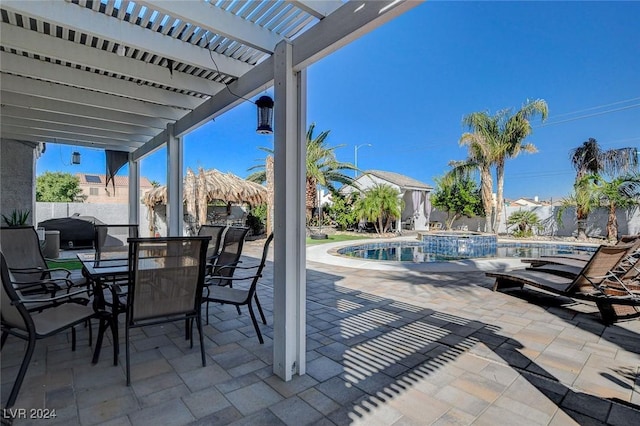 view of patio with a swimming pool with hot tub, a pergola, and area for grilling