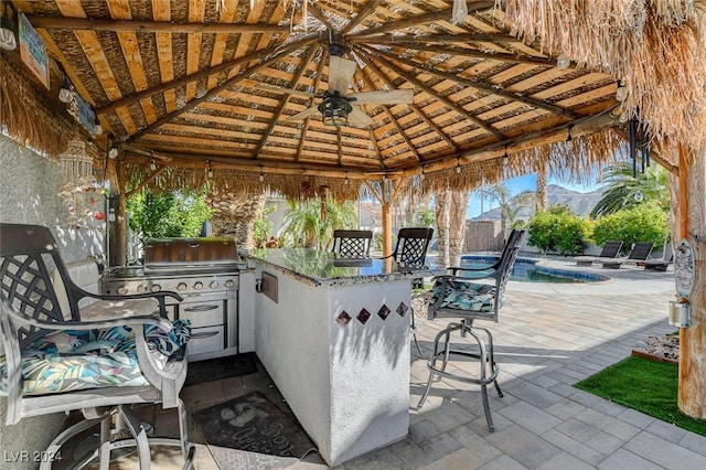 view of patio / terrace featuring a bar, a gazebo, and exterior kitchen