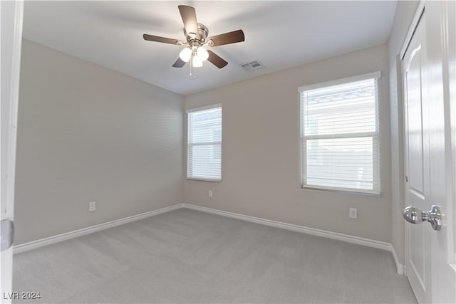 carpeted spare room with ceiling fan