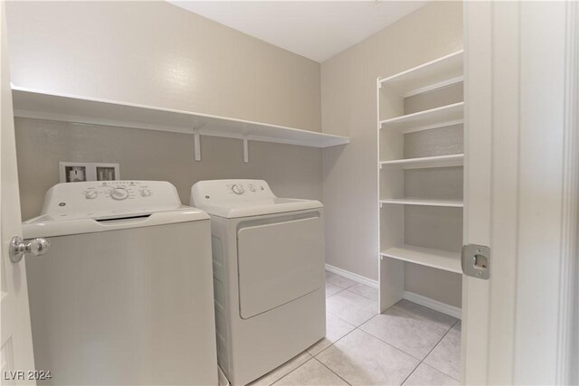 laundry area featuring light tile patterned flooring and washing machine and clothes dryer