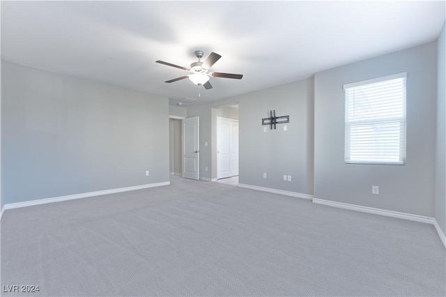 carpeted spare room with ceiling fan