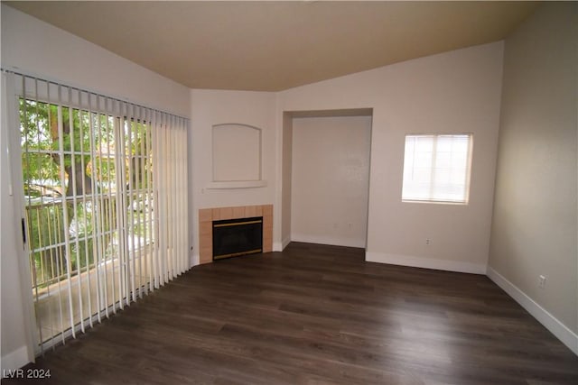 unfurnished living room featuring a tile fireplace and dark hardwood / wood-style floors