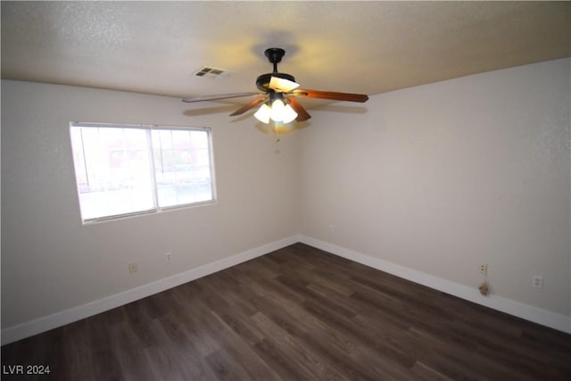 spare room featuring a textured ceiling, ceiling fan, and dark wood-type flooring