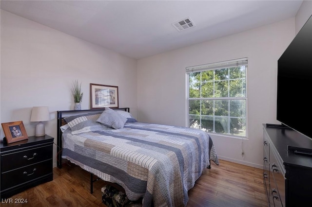 bedroom with dark hardwood / wood-style flooring