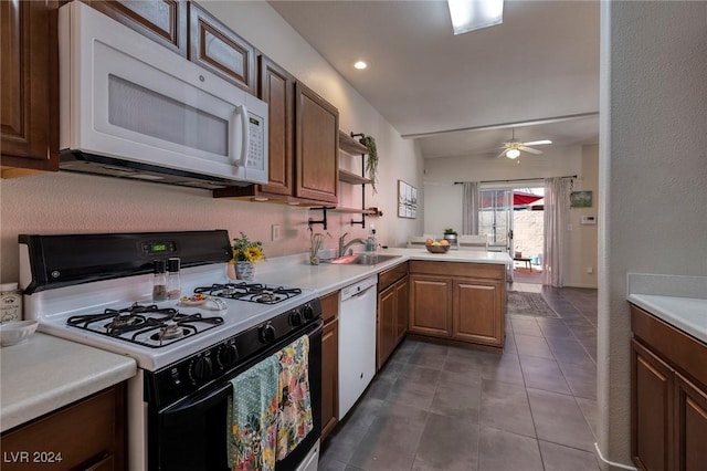 kitchen with white appliances, tile patterned floors, sink, ceiling fan, and kitchen peninsula