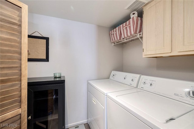 clothes washing area featuring washer and clothes dryer and cabinets