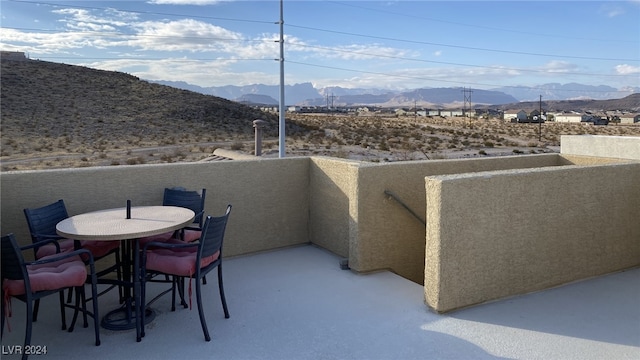 view of patio with a balcony and a mountain view