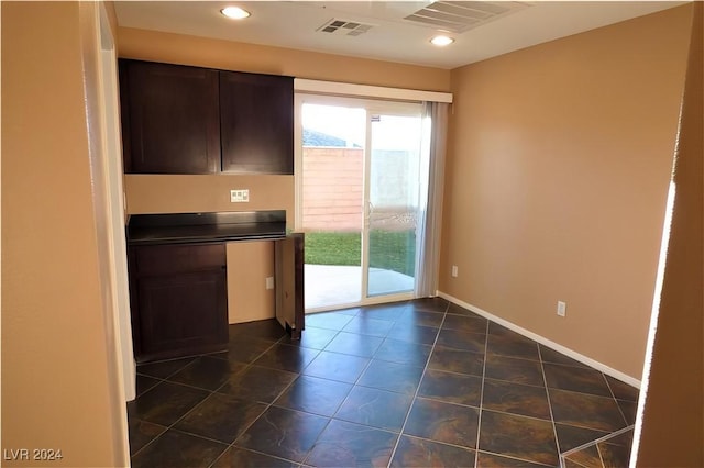 kitchen with dark brown cabinets and dark tile patterned floors