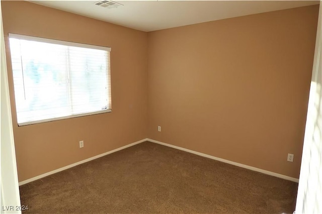 spare room featuring dark colored carpet