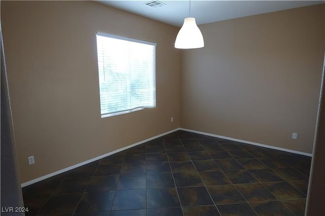 empty room featuring dark tile patterned floors