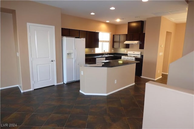 kitchen featuring dark brown cabinetry, a kitchen island, sink, and white appliances