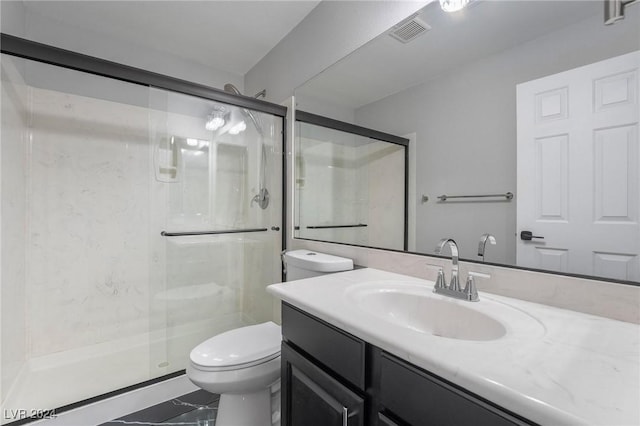 bathroom with toilet, a shower with door, and vanity