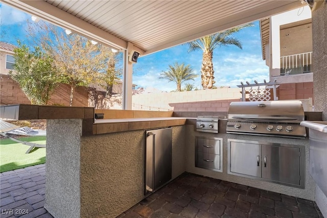 view of patio featuring area for grilling and a grill