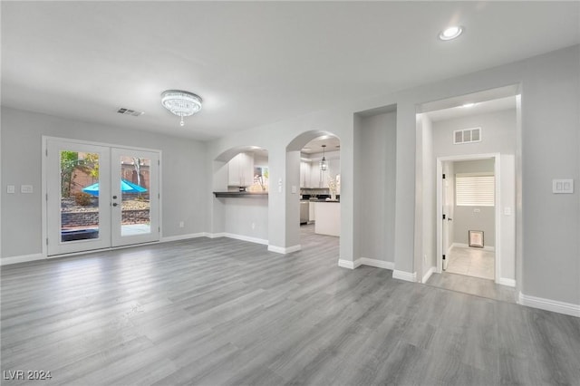 unfurnished living room featuring french doors and hardwood / wood-style floors