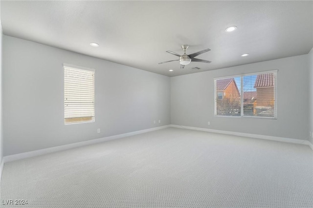 empty room with ceiling fan and light carpet