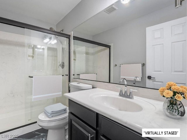 bathroom featuring toilet, a shower with shower door, and vanity