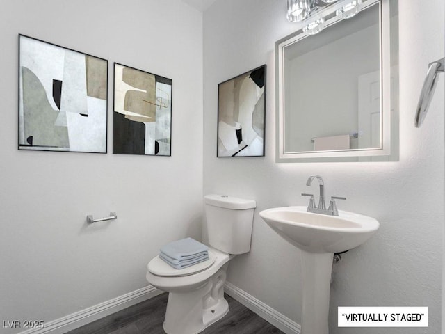 bathroom with toilet and hardwood / wood-style floors