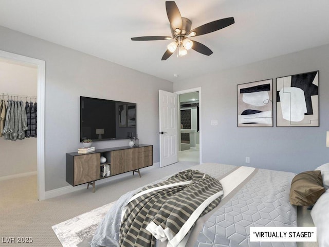 bedroom featuring a walk in closet, ceiling fan, a closet, and light carpet