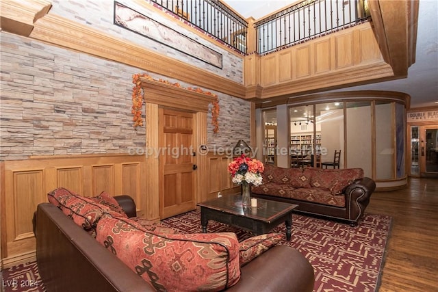 living room featuring a high ceiling, ornamental molding, and dark wood-type flooring