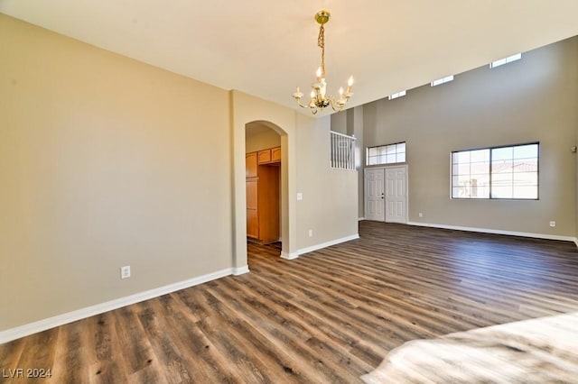 spare room with a chandelier and dark hardwood / wood-style floors