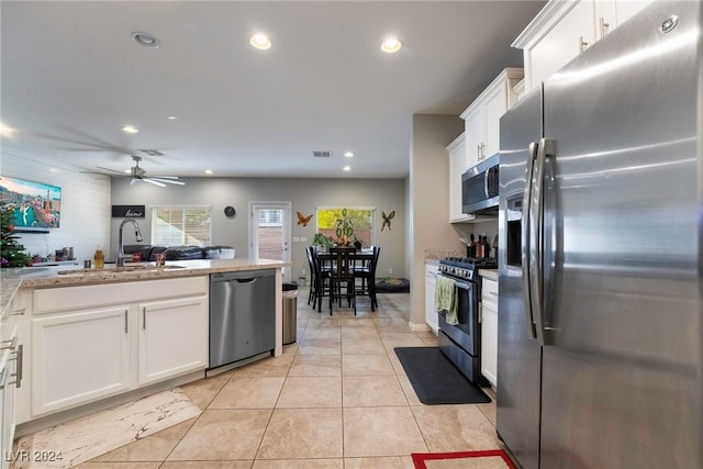 kitchen featuring white cabinets, sink, ceiling fan, appliances with stainless steel finishes, and light tile patterned flooring