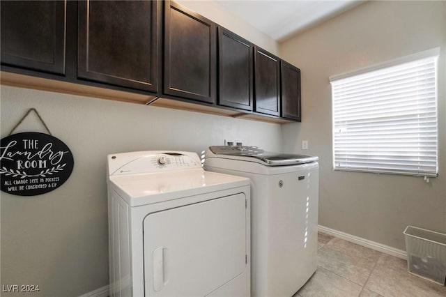 laundry area with cabinets, light tile patterned floors, and washing machine and dryer