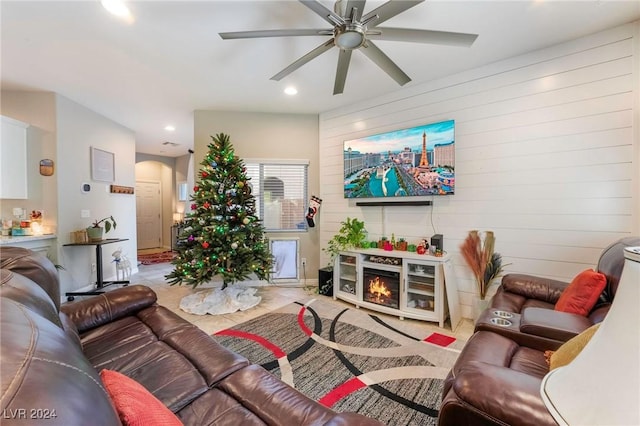 tiled living room featuring ceiling fan and wooden walls