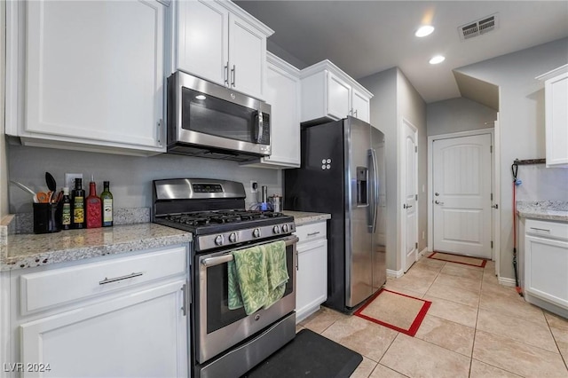 kitchen with light stone counters, white cabinets, stainless steel appliances, and light tile patterned floors