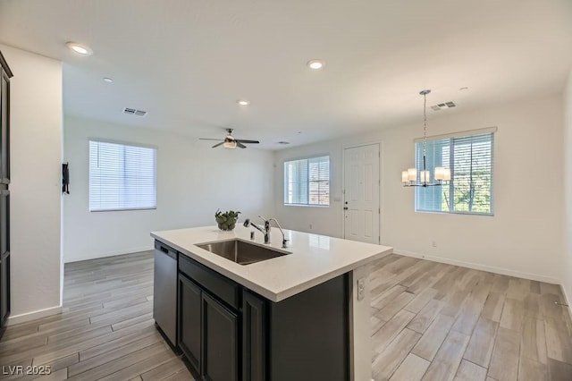 kitchen with sink, a center island with sink, a wealth of natural light, and hanging light fixtures