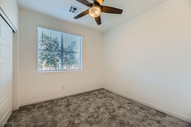 empty room featuring ceiling fan and carpet